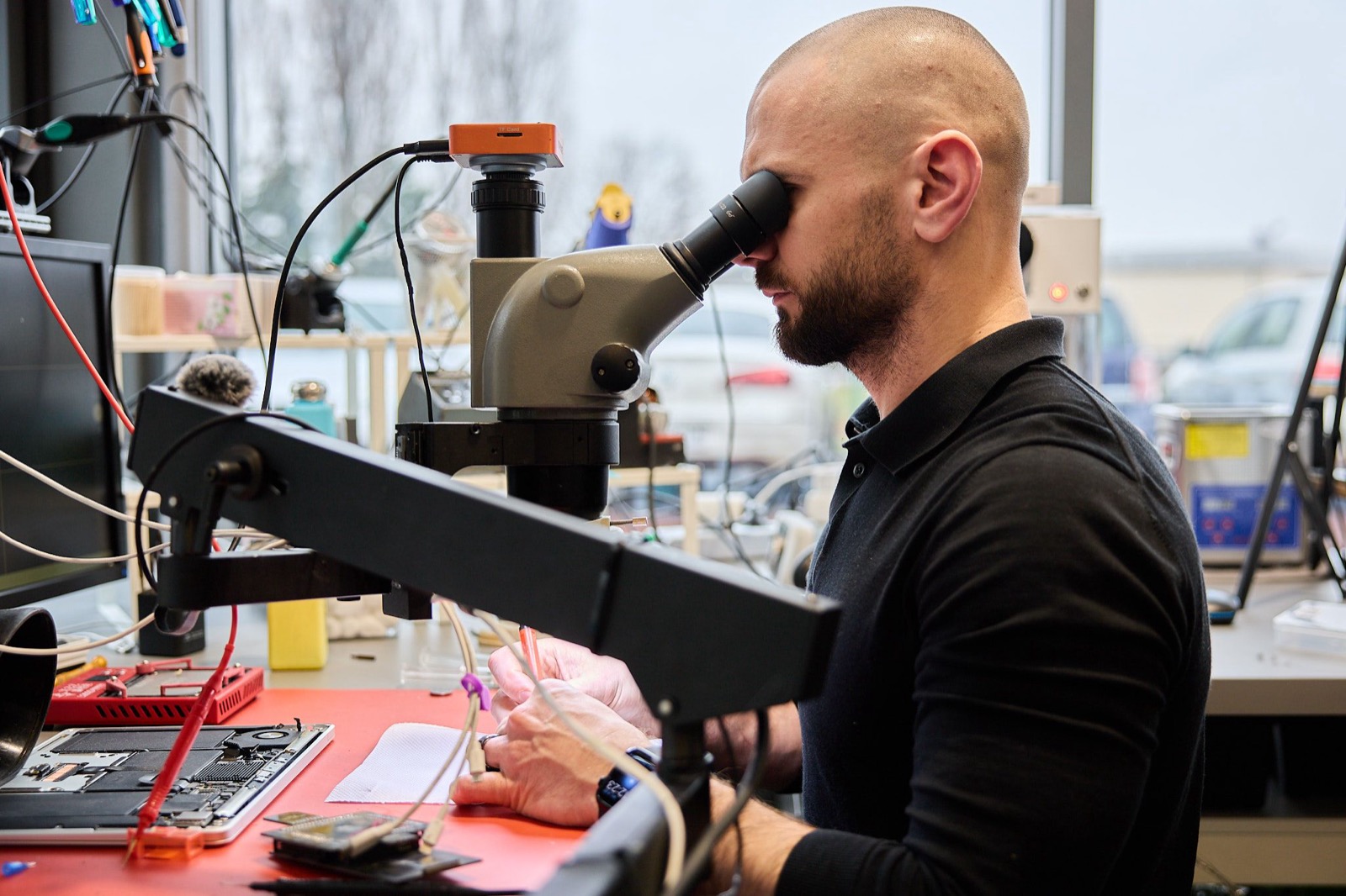 Paweł przy mikroskopie w laboratorium odzysku danych